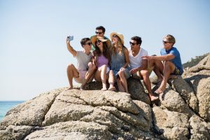Friends taking selfie while sitting on rock formations