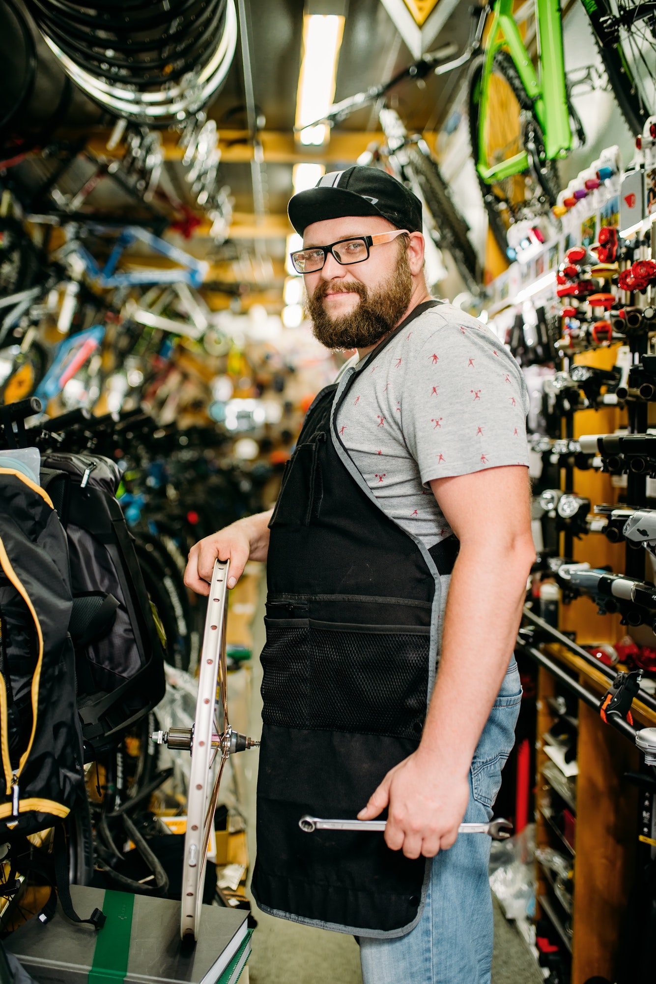 Bicycle mechanic with wheel in bike shop