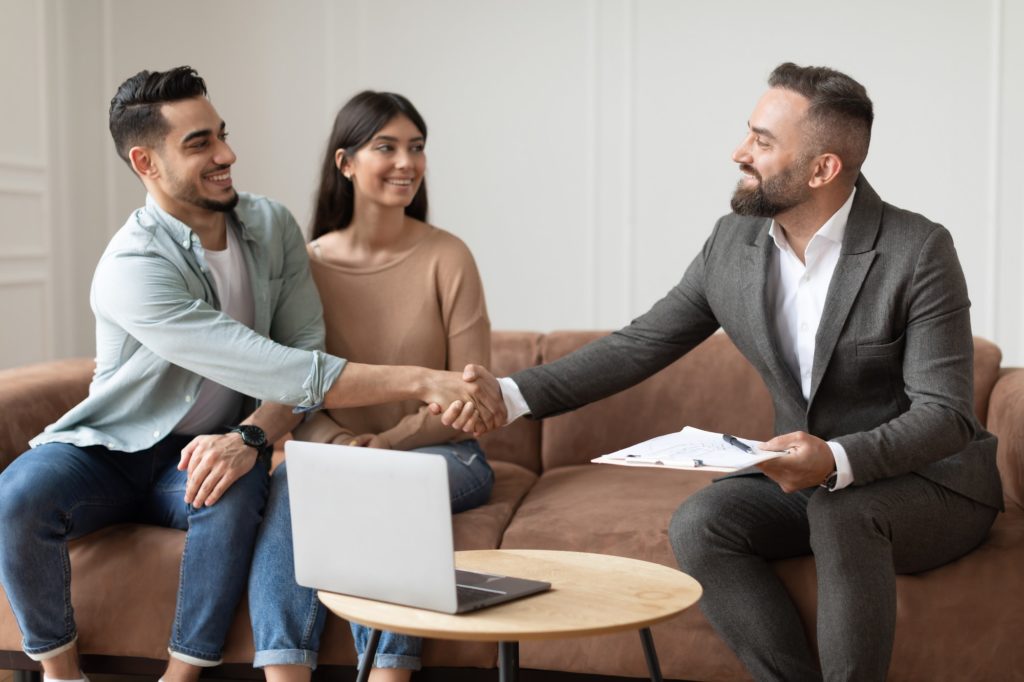 Couple Buying New Apartment, Shaking Hands With Realtor